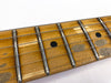 Close-up of vintage maple guitar fretboard with metal frets and black dot inlays under steel strings on white background
