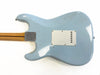 Back of light blue electric guitar body with cream plastic cover plate and natural wood neck with skunk stripe, showing wear and vintage finish details