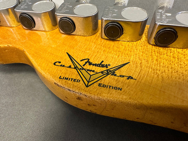 Close-up of Fender Custom Shop Limited Edition guitar headstock with tuning pegs and natural wood finish.