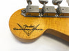 Close-up of Fender Custom Shop logo and vintage tuning machines on natural wood guitar headstock