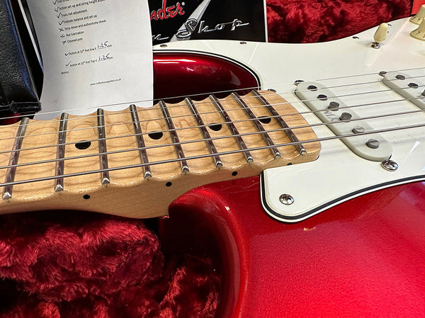 Close-up of red electric guitar neck and strings with maple fretboard and white pickguard in plush red case at Coffee House Guitars