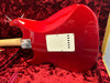 Red Fender electric guitar body back with white tremolo cavity cover in red plush-lined guitar case