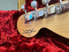 Close-up of Fender Custom Shop guitar headstock with chrome tuning pegs on red plush guitar case lining