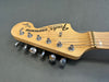 Close-up of Fender Stratocaster maple guitar headstock with chrome tuning pegs and string retainer on gray background