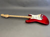 Red Fender Stratocaster electric guitar with maple neck and white pickguard on gray background
