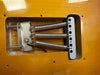 Close-up of electric guitar tremolo spring cavity with three metal springs and mounting hardware on natural wood finish body