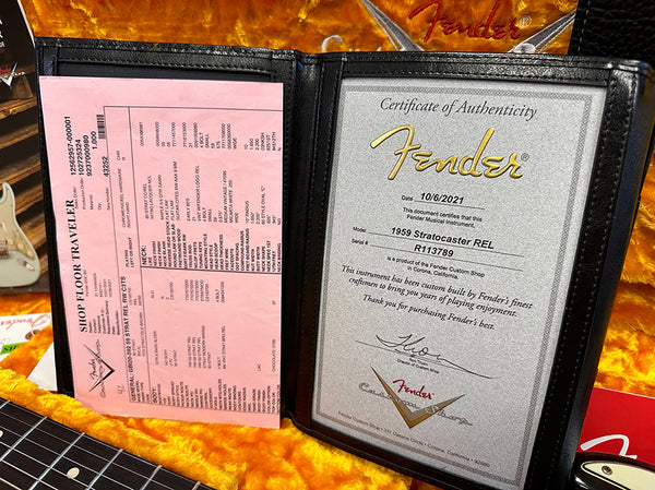 Fender Certificate of Authenticity for 1959 Stratocaster REL with serial number R113789, inside black leather case with detailed build specs sheet, on orange plush guitar case lining.