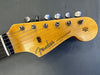 Close-up of Fender Stratocaster guitar headstock with six tuning pegs on natural wood finish and "Original Contour Body" text
