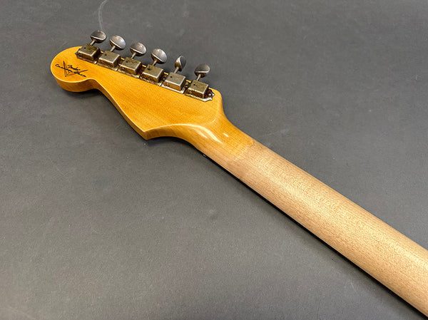 Close-up of vintage Fender electric guitar maple neck and headstock with tuning pegs on gray background