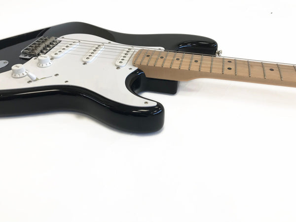 Black electric guitar with maple neck and white pickguard on white background