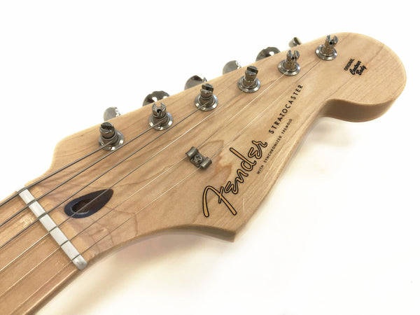 Close-up of natural wood Fender Stratocaster electric guitar headstock with tuning pegs and strings on white background