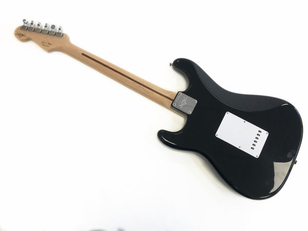 Back view of black electric guitar with maple neck, chrome tuning pegs, and white back plate on a white background