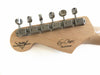 Close-up of Fender Custom Shop guitar headstock with vintage-style tuning pegs and "Blackie" signature decal on natural wood finish