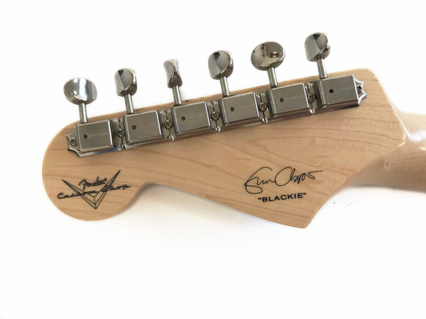 Close-up of Fender Custom Shop guitar headstock with vintage-style tuning pegs and "Blackie" signature decal on natural wood finish