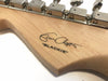 Close-up of maple guitar headstock with tuners and Eric Clapton "BLACKIE" signature decal