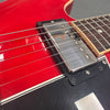 Close-up of electric guitar chrome pickup and strings on red and black body with white trim at Coffee House Guitars product listing