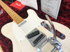 Close-up of Fender limited edition white electric guitar with Bigsby vibrato tailpiece on red velvet lining inside guitar case, showing maple neck and chrome hardware