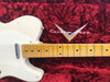 Vintage white Fender Telecaster electric guitar with maple neck and chrome pickup resting on red plush Fender Custom Shop guitar case interior