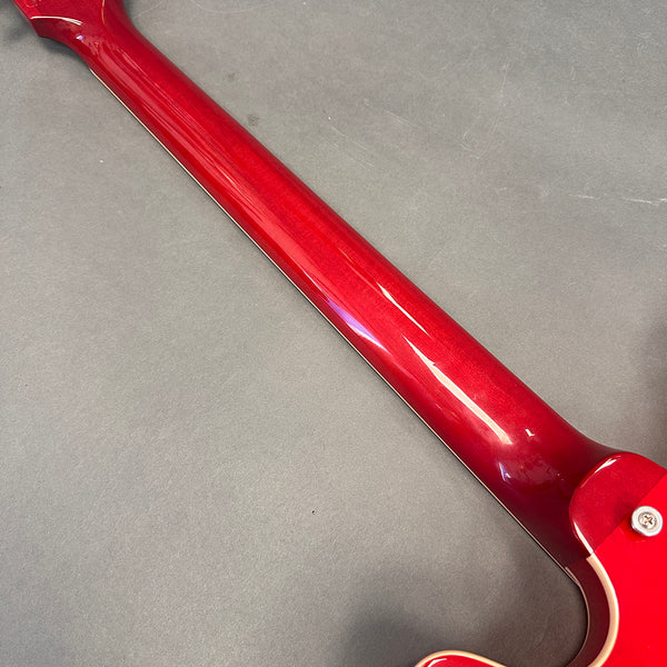 Glossy red guitar neck on gray background showing smooth finish and craftsmanship