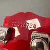 Close-up of red guitar headstock showing serial number 1111734 and Grover tuning pegs