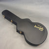 Black Gibson Custom guitar hard case with gold latches on gray background