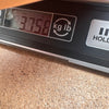 Digital scale displaying guitar weight of 3.758 kilograms on a wooden surface at Coffee House Guitars
