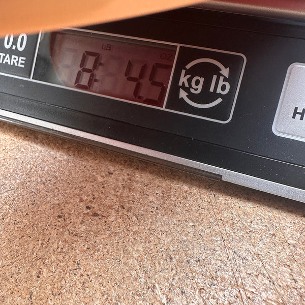 Digital scale showing a weight measurement of 8 pounds 4.5 ounces with option to switch between kilograms and pounds units.