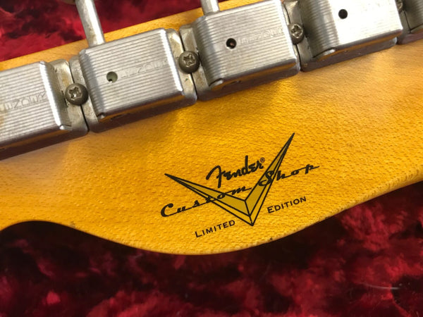 Close-up of Fender Custom Shop Limited Edition guitar headstock with vintage tuning machines on red plush background
