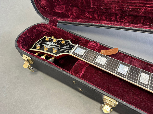 Gibson Les Paul electric guitar headstock and neck with pearl block inlays in black hard case with red velvet interior