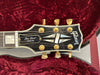 Gibson Les Paul Custom guitar headstock with gold tuning pegs and mother of pearl inlays inside red velvet guitar case