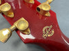 Close-up of red Gibson Custom Shop guitar headstock with gold Grover tuning pegs and Gibson Custom Shop logo badge