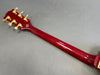 Back view of red guitar neck and headstock with gold tuning pegs on gray background from Coffee House Guitars product listing