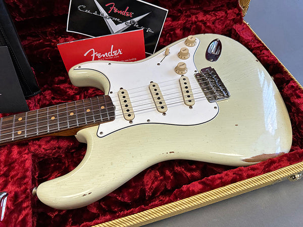 Fender vintage electric guitar with white finish, three single-coil pickups, and rosewood fretboard in red plush-lined hard case with Fender paperwork