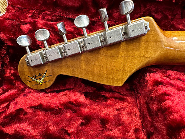 Close-up of Fender Custom Shop Limited Edition guitar headstock with vintage tuning pegs on red plush background