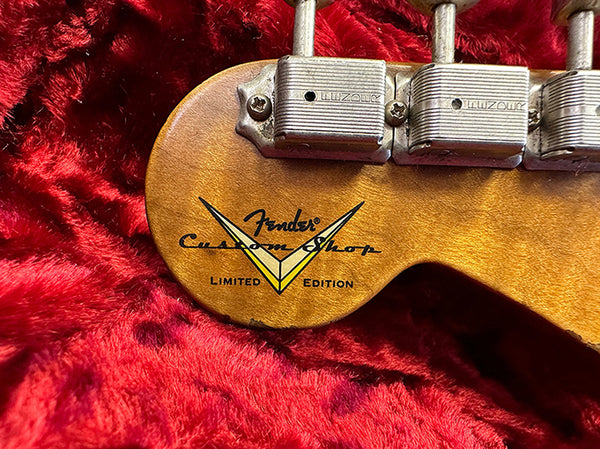 Close-up of Fender Custom Shop Limited Edition guitar headstock with vintage tuning pegs on red plush fabric background