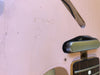 Close-up of pink electric guitar body showing faint serial number and part of the pickup and fretboard with dot inlay and metal fret