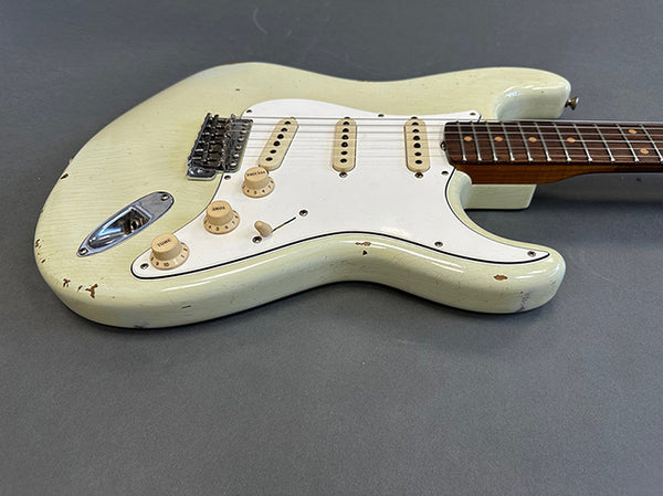 Vintage white electric guitar with rosewood fretboard and white pickguard showing worn and distressed finish on gray background
