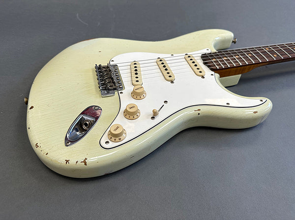 Vintage white electric guitar with three single-coil pickups and maple fretboard on gray background