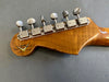 Back of Fender Custom Shop Limited Edition electric guitar headstock with six vintage tuning pegs on maple neck against gray background