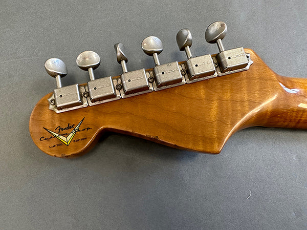 Back of Fender Custom Shop Limited Edition electric guitar headstock with six vintage tuning pegs on maple neck against gray background