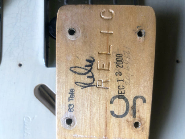 Close-up of neck heel of a 1963 Fender Telecaster guitar showing "63 Tele" stamp, handwritten "Rusty" signature, and stamped date "DEC 13 2000" with model code "JC" embossed on the wood.
