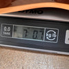 Close-up of digital scale showing 7 pounds and 0.7 ounces weight for guitar at Coffee House Guitars