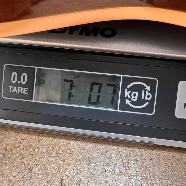 Close-up of digital scale showing 7 pounds and 0.7 ounces weight for guitar at Coffee House Guitars