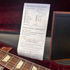 Gibson guitar pre-pack checklist inside guitar case with part of guitar fretboard and case visible