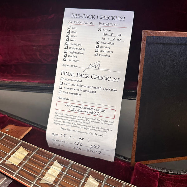 Gibson guitar pre-pack checklist inside guitar case with part of guitar fretboard and case visible
