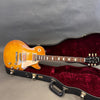 Gibson Les Paul electric guitar with sunburst finish and dual humbucker pickups in open black hard case with red velvet interior