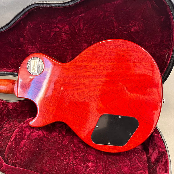 Back view of Gibson Les Paul electric guitar with red finish inside a plush red velvet guitar case