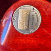 Close-up of Gibson Custom guitar metal back plate on red wood finish body, showing "Gibson Custom EST. 1894 Made in U.S.A." engraving