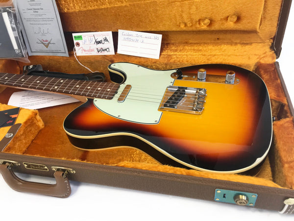 Fender Custom Shop Telecaster electric guitar in sunburst finish with white pickguard, chrome hardware, and rosewood fretboard inside vintage-style orange plush-lined hard case with Fender logo and certificate of authenticity.