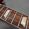 Close-up of rosewood guitar fretboard with mother-of-pearl block inlays and steel strings on electric guitar guitar neck